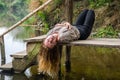 Young beautiful woman model with long blond hair sitting with different emotions laughter, sadness, sorrow, thoughtfulness on a wo Royalty Free Stock Photo