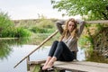 Young beautiful woman model with long blond hair sitting with different emotions laughter, sadness, sorrow, thoughtfulness on a wo Royalty Free Stock Photo