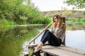 Young beautiful woman model with long blond hair sitting with different emotions laughter, sadness, sorrow, thoughtfulness on a wo Royalty Free Stock Photo