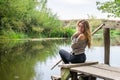 Young beautiful woman model with long blond hair sitting with different emotions laughter, sadness, sorrow, thoughtfulness on a wo Royalty Free Stock Photo