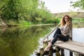 Young beautiful woman model with long blond hair sitting with different emotions laughter, sadness, sorrow, thoughtfulness on a wo Royalty Free Stock Photo