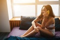 Young beautiful woman in morning on bed. Talking on phone and smile. Conversation time in bed. Alone in room talking. Royalty Free Stock Photo