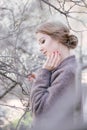 Young beautiful woman near trees in blossom in spring. Hair style bound Royalty Free Stock Photo