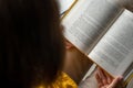 Young beautiful woman near window yellow knitted sweater read book