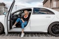 Young beautiful woman out of a white car. Young smiling woman getting out of car. Royalty Free Stock Photo