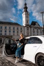 Young beautiful woman out of a white car. Young smiling woman getting out of car. Royalty Free Stock Photo