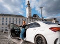 Young beautiful woman out of a white car. Young smiling woman getting out of car. Royalty Free Stock Photo