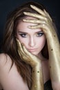 Young beautiful woman with perfect makeup and golden hands Royalty Free Stock Photo