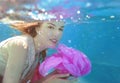 Young beautiful woman with pink flower underwater Royalty Free Stock Photo