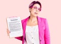 Young beautiful woman with pink hair holding clipboard with contract document looking sleepy and tired, exhausted for fatigue and Royalty Free Stock Photo