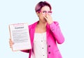 Young beautiful woman with pink hair holding clipboard with contract document smelling something stinky and disgusting, Royalty Free Stock Photo