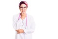 Young beautiful woman with pink hair wearing doctor uniform looking confident at the camera smiling with crossed arms and hand Royalty Free Stock Photo