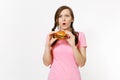 Young beautiful woman in pink t-shirt with braids holding in hands burger isolated on white background. Proper nutrition Royalty Free Stock Photo