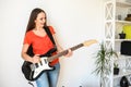 Young woman plays electric guitar at home Royalty Free Stock Photo