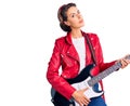 Young beautiful woman playing electric guitar thinking attitude and sober expression looking self confident Royalty Free Stock Photo