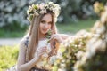 Young beautiful woman with a pleasant smile in alone in a wreath of fresh flowers walks in a spring flowering park Royalty Free Stock Photo