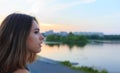 Young beautiful woman portrait against sunset in park and city at background Royalty Free Stock Photo