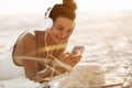 Woman in Bikini with a Smartphone and Headphones on the Beach Royalty Free Stock Photo