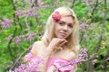 Young beautiful woman posing in blooming pink flowers spring park Royalty Free Stock Photo