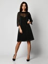 Young beautiful woman posing in new black fashion winter dress full body on a white