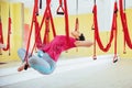 Young beautiful woman practicing yoga Fly with a hammock in the bright studio. The concept of mental and physical health Royalty Free Stock Photo