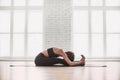 Young beautiful woman practicing yoga near floor window in yoga studio. Girl doing exercises at class. Royalty Free Stock Photo