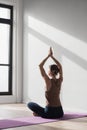 Young beautiful woman practicing yoga near floor window in yoga studio, Young beautiful girl doing exercises at home. Royalty Free Stock Photo