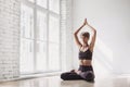 Young beautiful woman practicing yoga near floor window in yoga studio. Young beautiful girl doing exercises at home Royalty Free Stock Photo