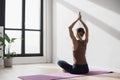 Young beautiful woman practicing yoga near floor window in yoga studio. Young beautiful girl doing exercises at home Royalty Free Stock Photo