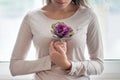 Young beautiful woman with purple floral flower cabbage near the window. Concept of beauty, natural herbal cosmetics