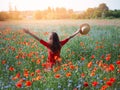 Young beautiful woman with raised arms in spring poppy field. Concept freedom and happiness summer Royalty Free Stock Photo