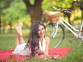 Young beautiful woman reading book outdoors in park on a sunny day Royalty Free Stock Photo