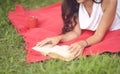 Young beautiful woman reading book outdoors in park on a sunny day Royalty Free Stock Photo