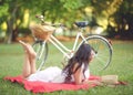 Young beautiful woman reading book outdoors in park on a sunny day Royalty Free Stock Photo