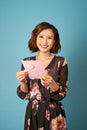 Young beautiful woman reading a love letter over light blue background Royalty Free Stock Photo