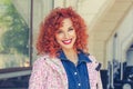 Young beautiful woman with red curly hair, smiling and looking you camera. Isolated at city car tree on background. Positive human Royalty Free Stock Photo