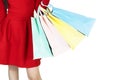 Young beautiful woman in red dress carrying color pastel shopping bag isolated banner white background with copy space Royalty Free Stock Photo