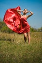 Young beautiful woman in red dress flying in wind Royalty Free Stock Photo