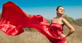 Young beautiful woman in red dress flying in wind Royalty Free Stock Photo