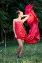 Young beautiful woman in red dress in green woods Royalty Free Stock Photo