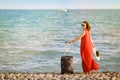 Woman in red dress with suitcase sea Royalty Free Stock Photo