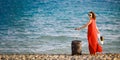 Woman in red dress with suitcase sea Royalty Free Stock Photo