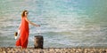 Woman in red dress with suitcase sea Royalty Free Stock Photo