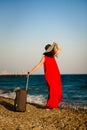 Woman in red dress with suitcase sea Royalty Free Stock Photo