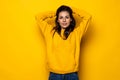 Young beautiful woman holding her hands on the head with happy exited emotional face isolated over yellow background Royalty Free Stock Photo