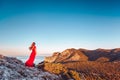 Young beautiful woman in red dress looking to mountains sea Royalty Free Stock Photo