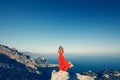 Young beautiful woman in red dress looking to mountains sea Royalty Free Stock Photo