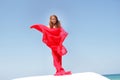 Young beautiful woman in red dress over bly sky Royalty Free Stock Photo