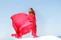 Young beautiful woman in red dress over bly sky Royalty Free Stock Photo