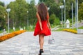 Young beautiful woman in red dress walking on the summer street Royalty Free Stock Photo